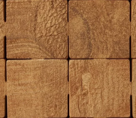 Dettaglio macro di blocchi di legno grezzo che si incastrano perfettamente tra loro, creando una struttura solida e simmetrica.
