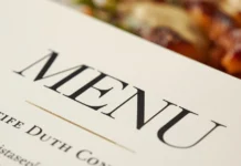 Dettaglio macro di un menù di design su un tavolo da ristorante.