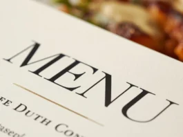 Dettaglio macro di un menù di design su un tavolo da ristorante.