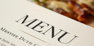 Dettaglio macro di un menù di design su un tavolo da ristorante.