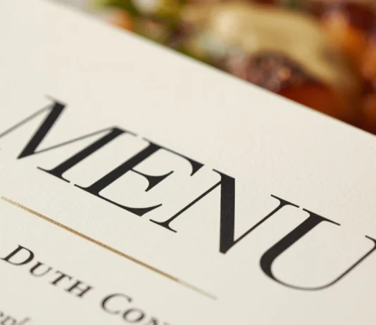 Dettaglio macro di un menù di design su un tavolo da ristorante.