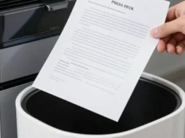 Mano che mantiene un comunicato stampa sopra un cestino, simbolo di selezione editoriale