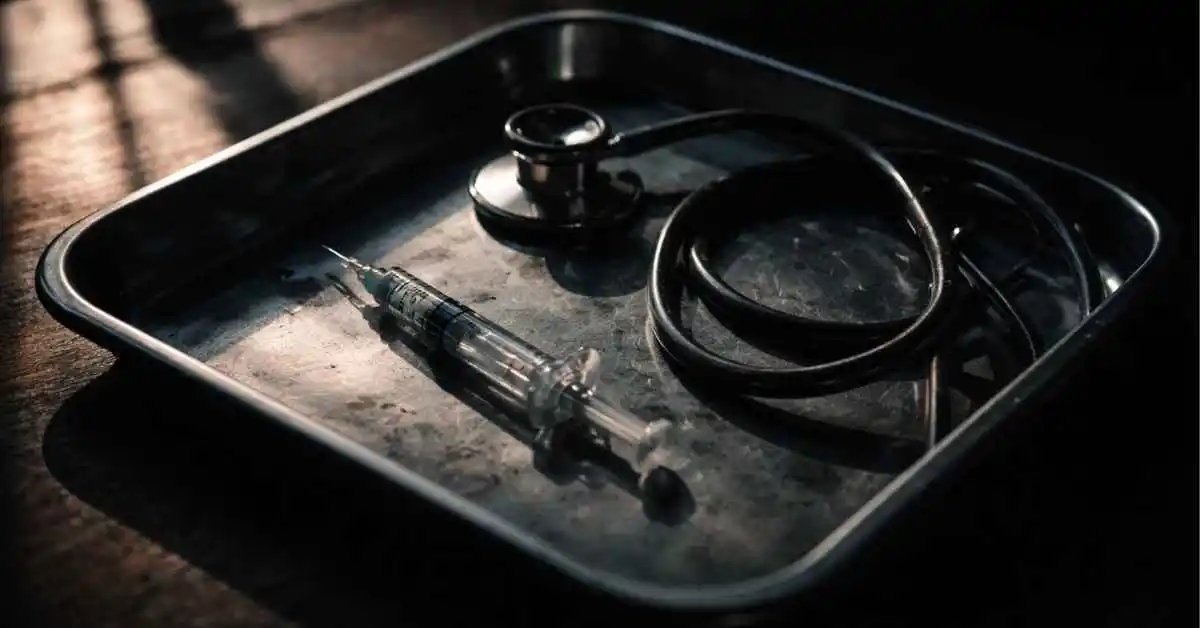 Particolare-di-una-siringa-e-uno-stetoscopio-su-sfondo-scuro_-simbolo-del-tradimento-della-cura-medi